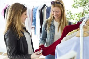 Two beautiful young women shopping in a clothes shop.